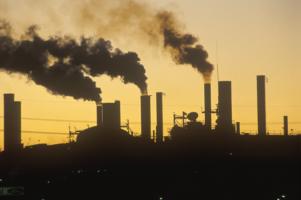 Industrial smokestacks against the sunset